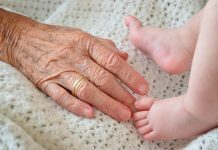 Picture of an older person’s hand and a kid’s legs
